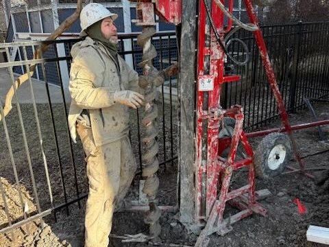 Compact Earth Power drill rig working in a narrow Chicago backyard beside a fence