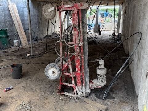 Drill rig set up inside a basement to reach the loop field from under the building