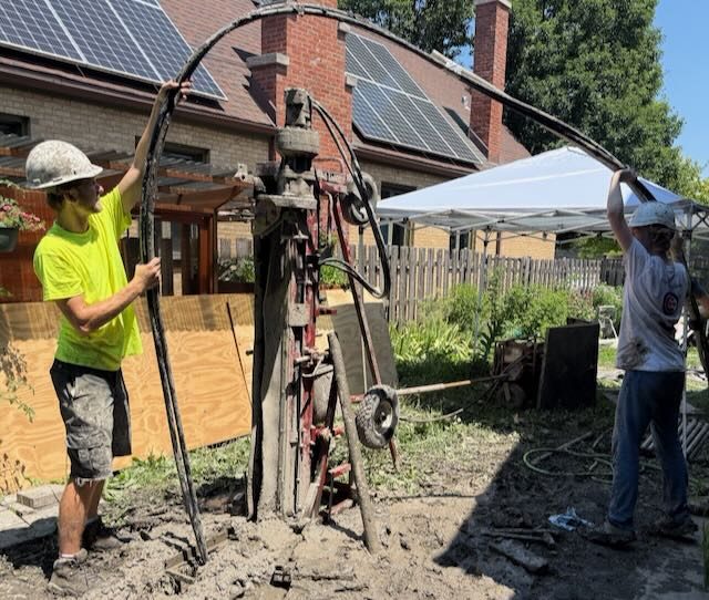 Earth Power crew pushing a geothermal ground loop into a completed borehole